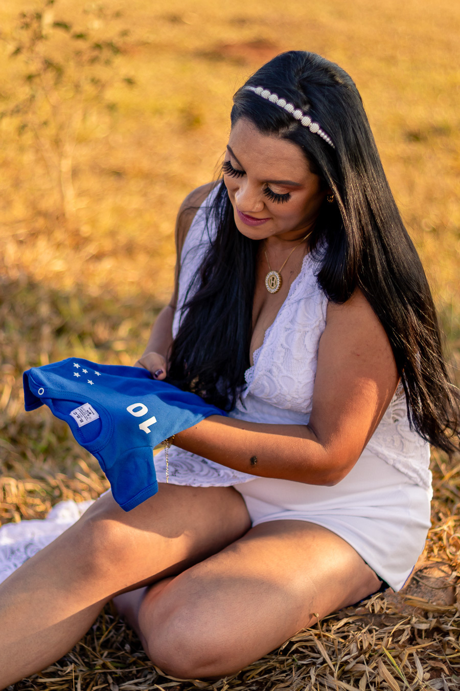 Heloisa sentada olhando a camisa do Cruzeiro em suas mãos, foto realizada pelo fotografo Anderson Rezende
