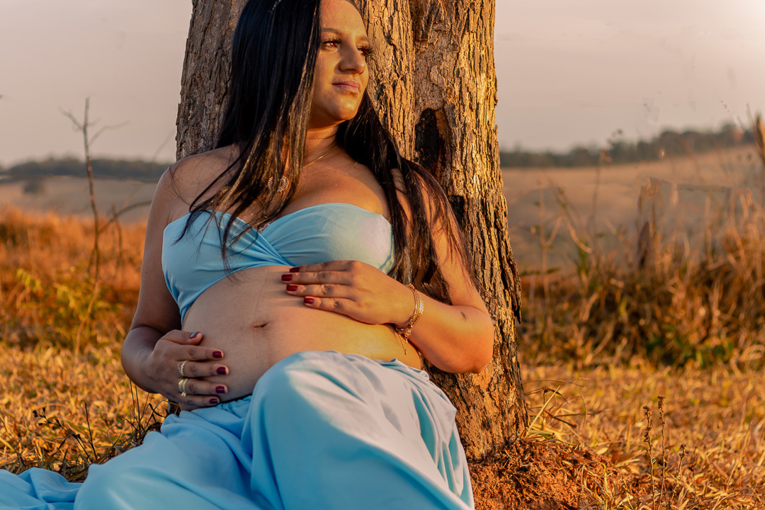Heloisa sentada embaixo da arvore olhando para o por do sol, foto realizada pelo fotografo Anderson Rezende