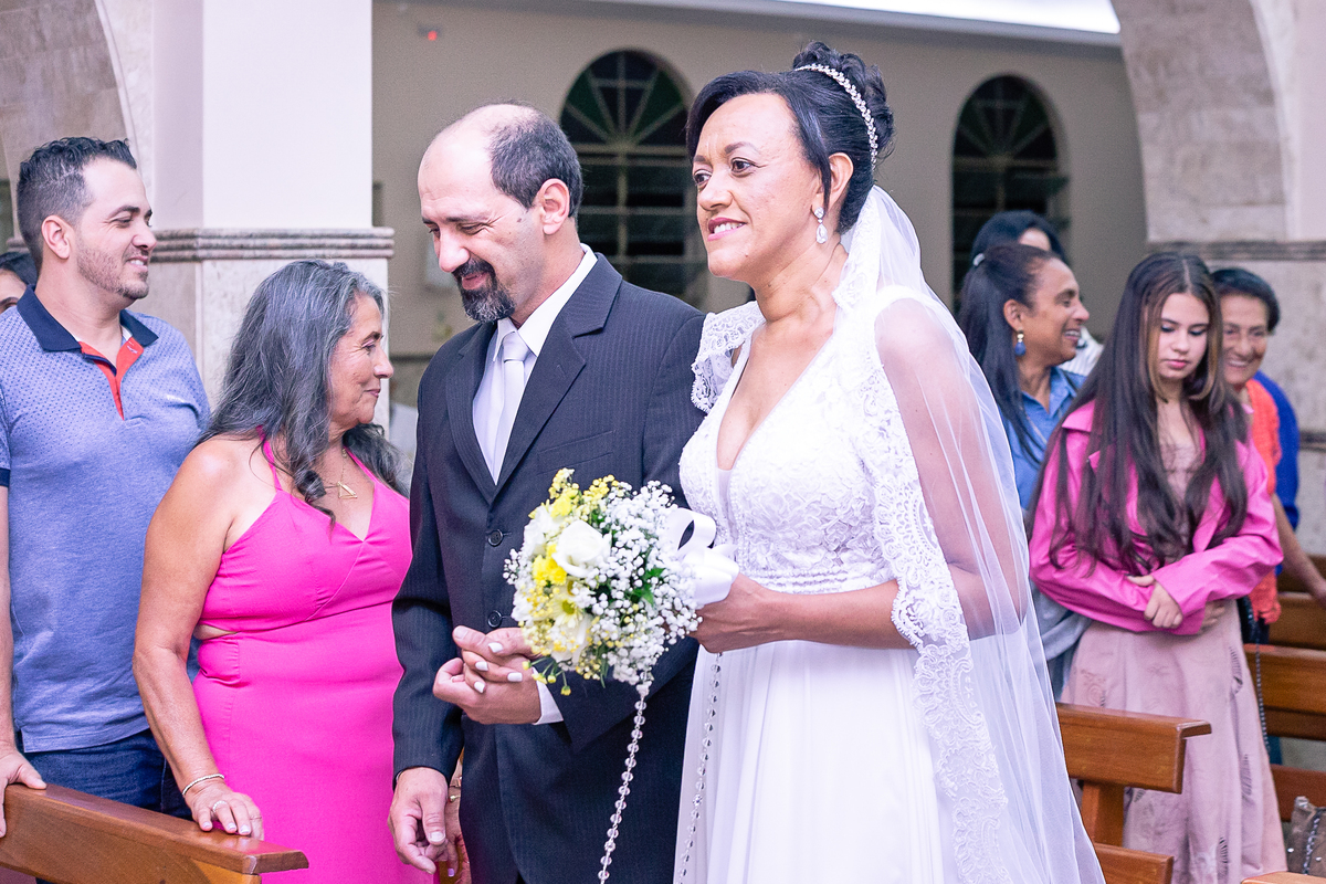 NOIVOS CAMINHANDO PELO CENTRO DA IGREJA EM DIREÇÃO AO ALTAR