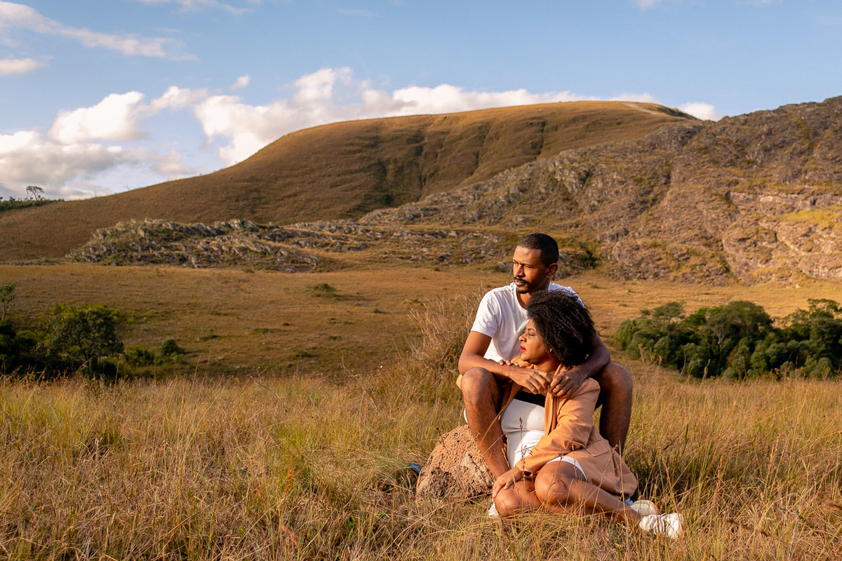 Casal sentado na Pedra olhando para o Horizonte