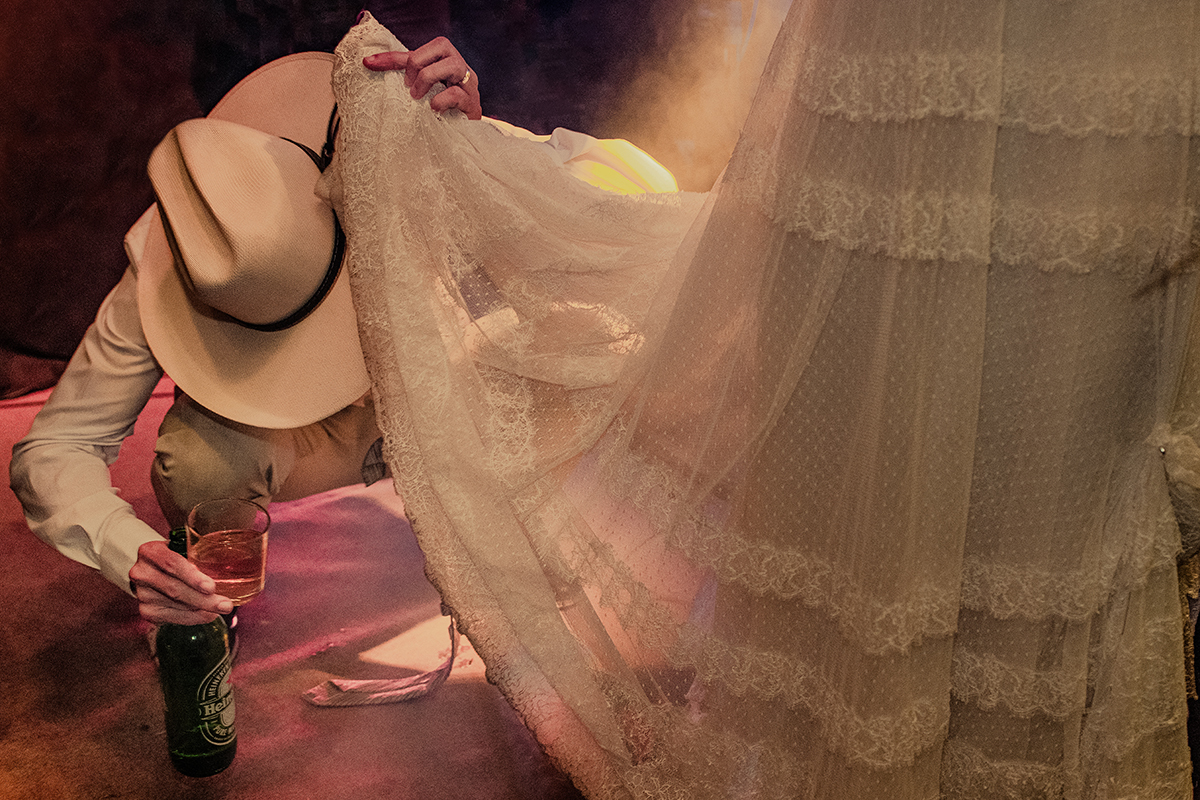 Noivo olhando em baixo do vestido da noiva antes da lua de mel. Foto premiada HIstorias Reais Valter Lombello.