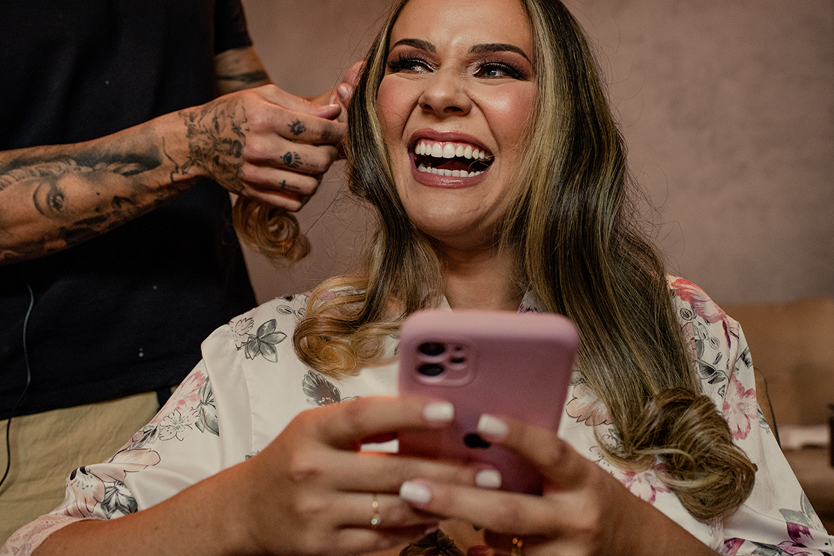 Sorriso da noiva vendo seu buquê de casamento.