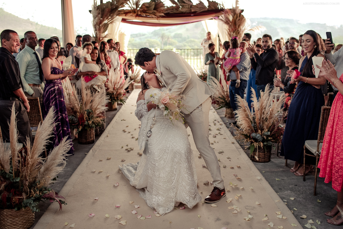 Beijo na saída dos noivos no casamento ao ar livre na Pousada Lagos de Minas em Tiradentes - MG.