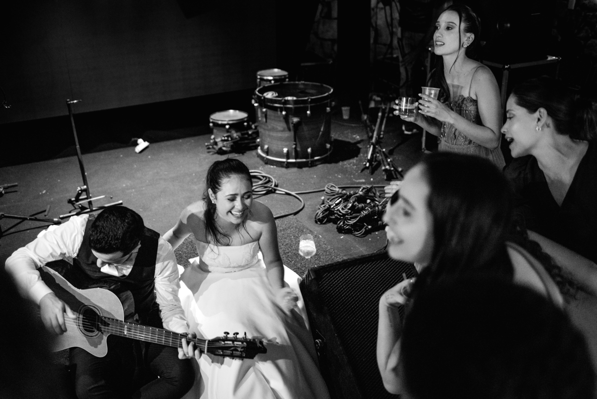 Noivos cantando e tocando violão na festa de casamento no palco.