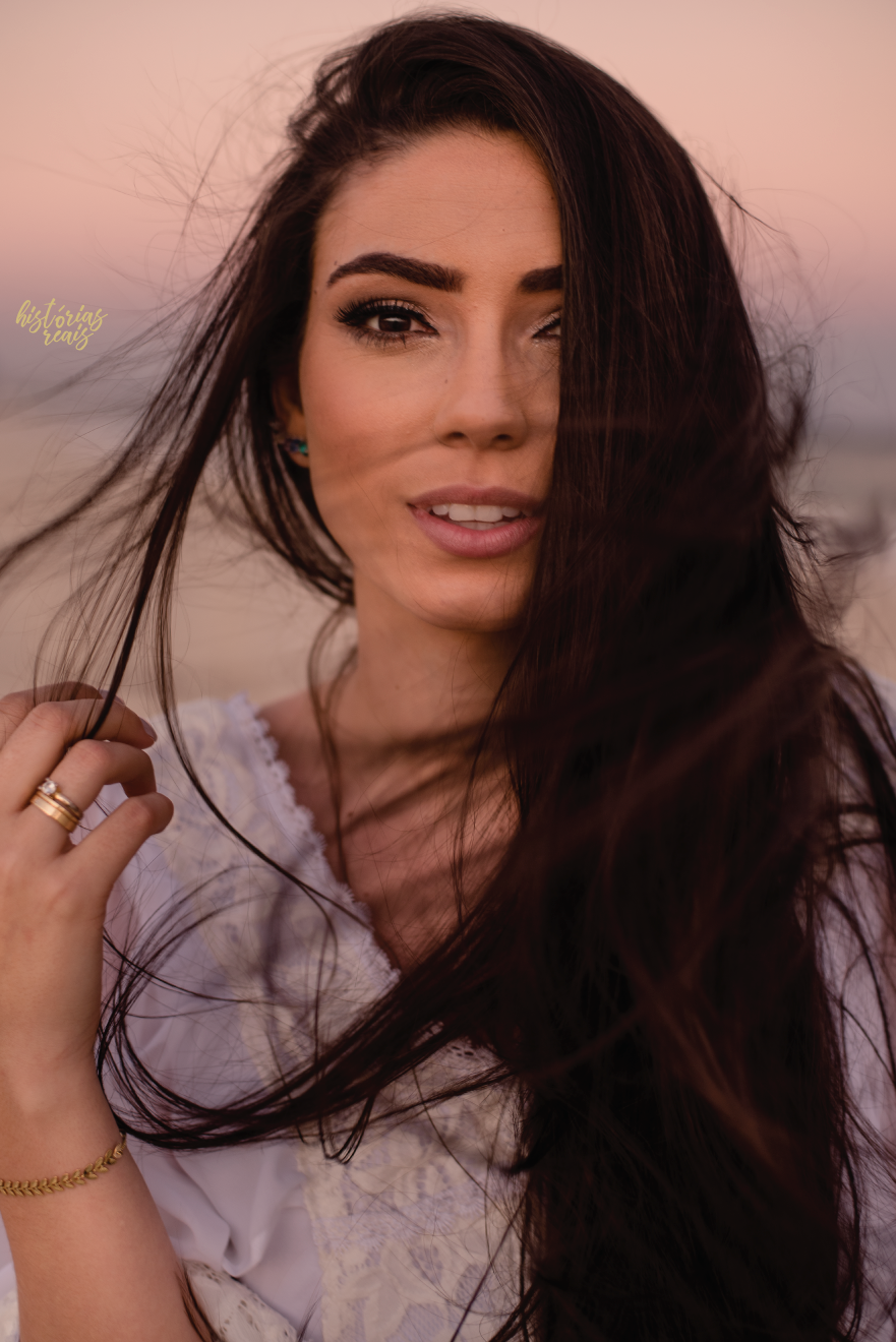 Retrato de noiva no ensaio pre wedding na praia de vestido branco.