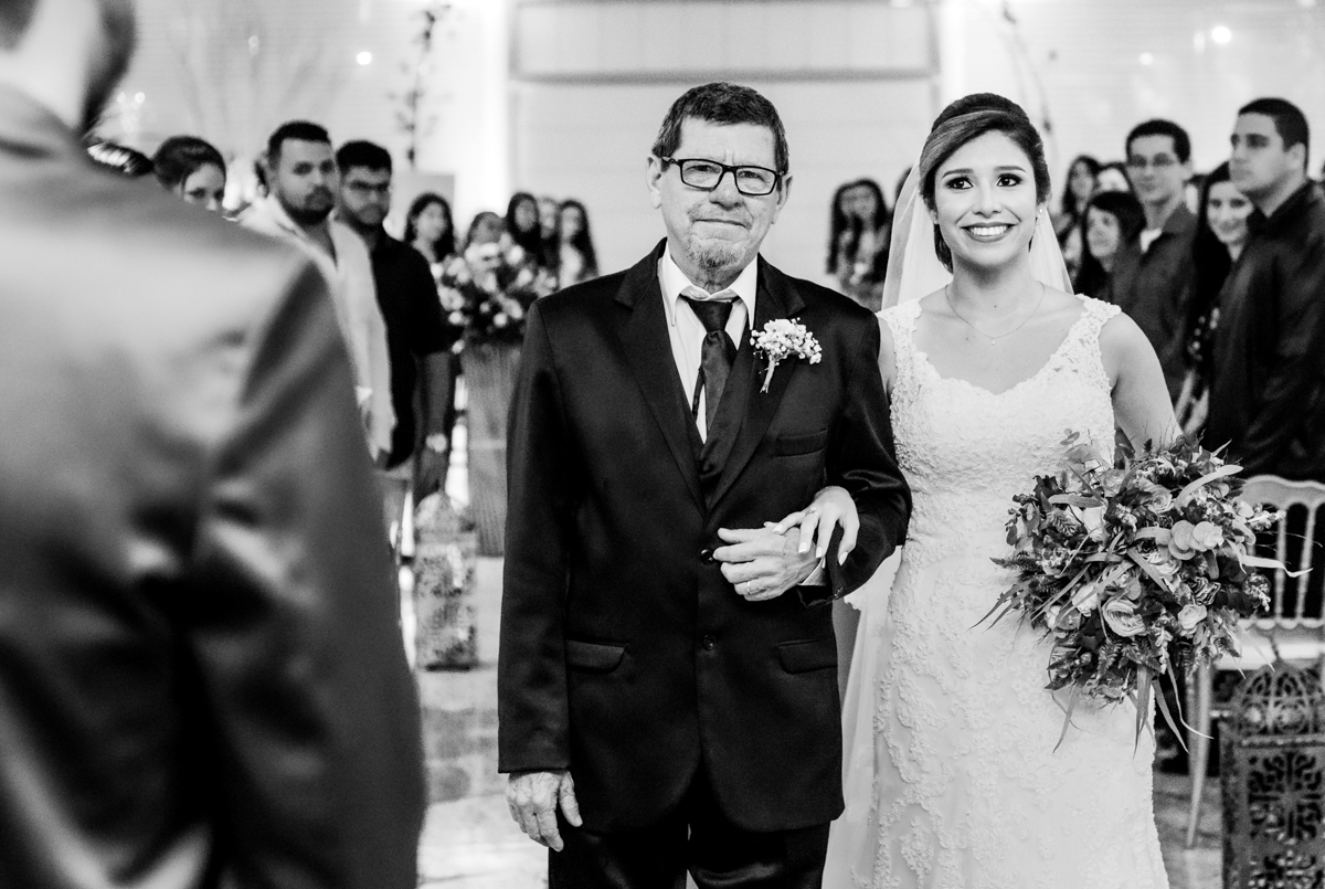 Fotografia da entrada da noiva olhando para o noivo. casamento realizado no Sítio Martins Eventos, em Cosmos, RJ.