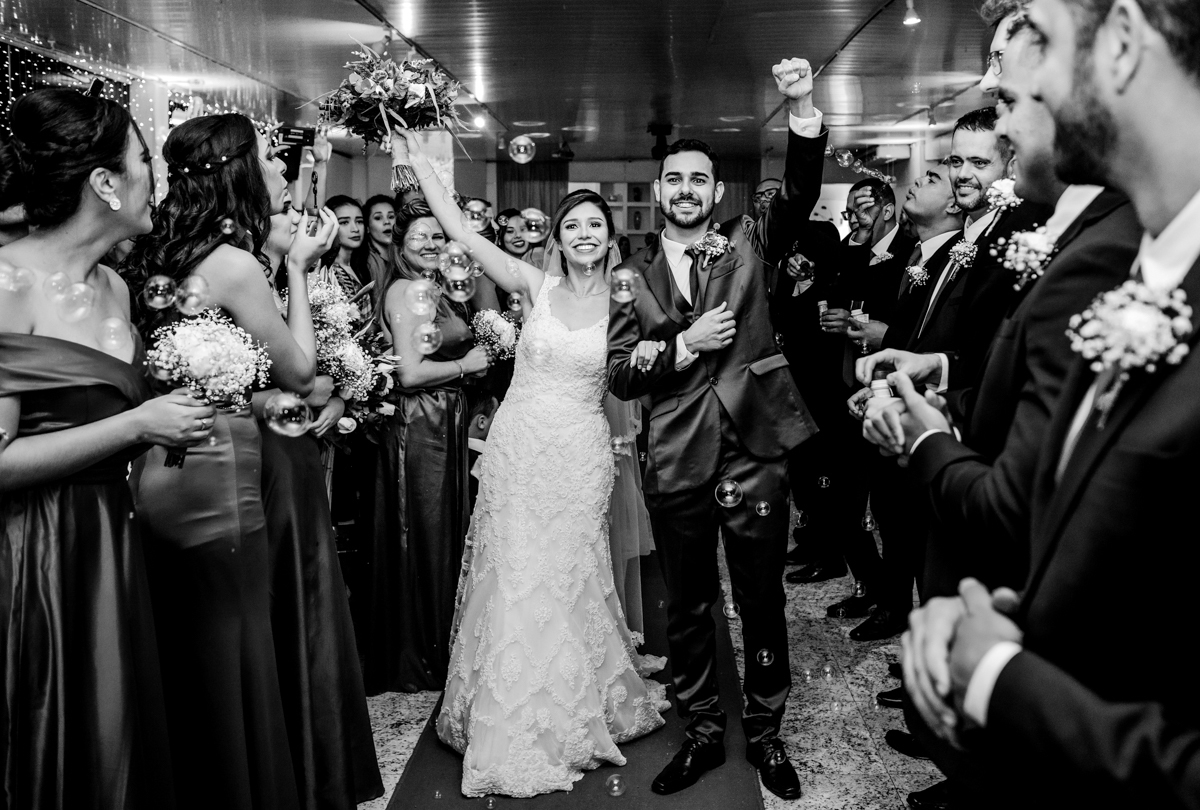 Fotografia da saída dos noivos da cerimônia. casamento realizado no Sítio Martins Eventos, em Cosmos, RJ.
