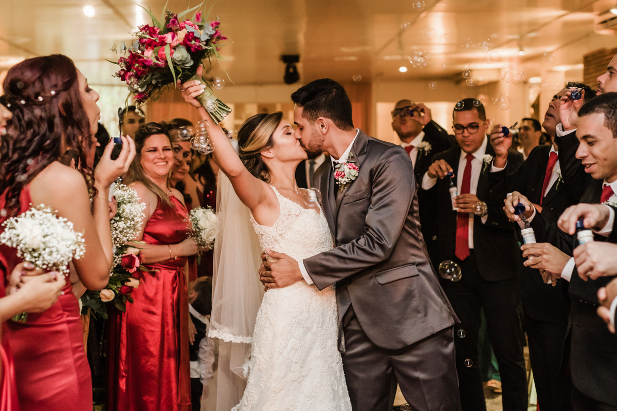 Fotografia da saída dos noivos da cerimônia. casamento realizado no Sítio Martins Eventos, em Cosmos, RJ.