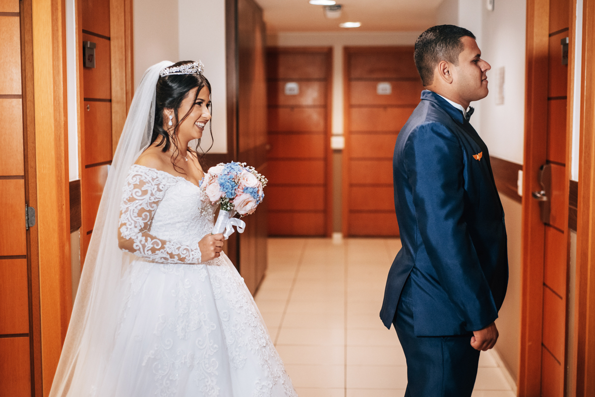 Fotografia de First touch da noiva Mariana e do noivo Matheus, em corredor do hotel, em seu making of, realizado no Hotel Mercure, em Nova Iguaçu, RJ.