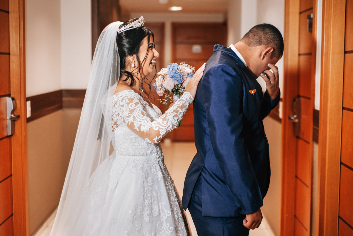 Fotografia de First touch da noiva Mariana e do noivo Matheus, em corredor do hotel, em seu making of, realizado no Hotel Mercure, em Nova Iguaçu, RJ.