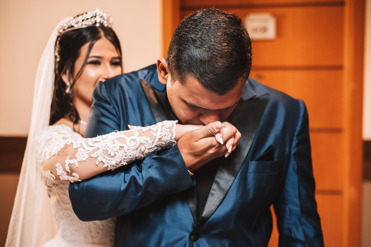 Fotografia de First touch da noiva Mariana e do noivo Matheus, em corredor do hotel, em seu making of, realizado no Hotel Mercure, em Nova Iguaçu, RJ.