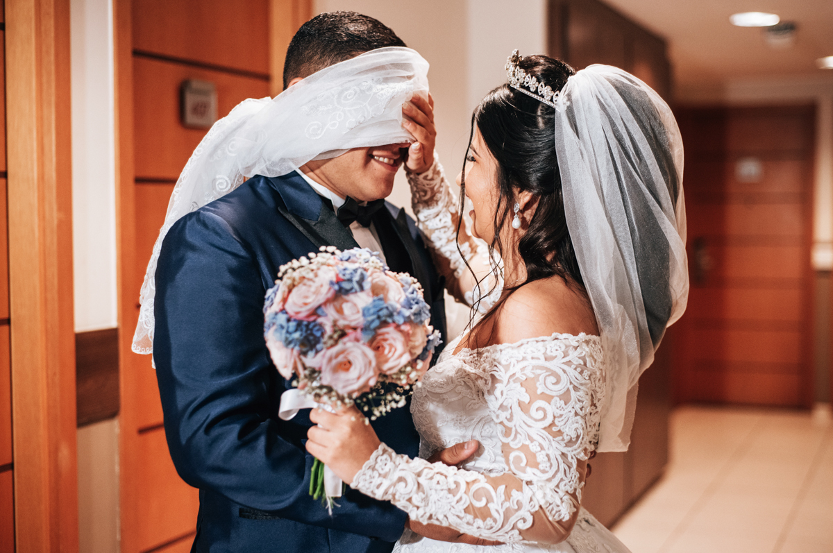 Fotografia de First touch da noiva Mariana e do noivo Matheus, em corredor do hotel, em seu making of, realizado no Hotel Mercure, em Nova Iguaçu, RJ.