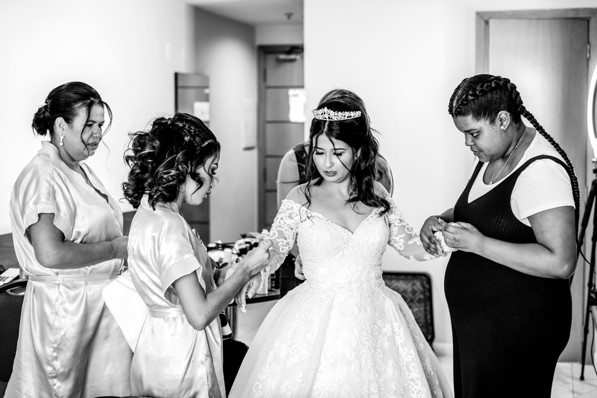 Fotografia do making of da noiva colocando o vestido, realizado no Hotel Mercure, em Nova Iguaçu, RJ.