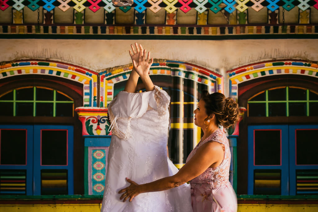 A mãe da noiva ajudando a vestir o vestido de noiva