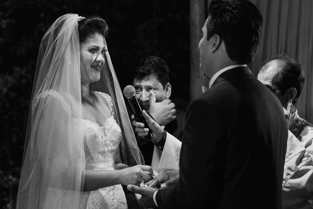 a hora das trocas das alianças a noiva, o noivo e o pai segurando as lagrimas