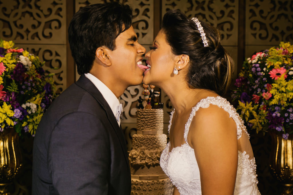 na messa do bolo de casamento a noiva mordendo a língua do seu marido