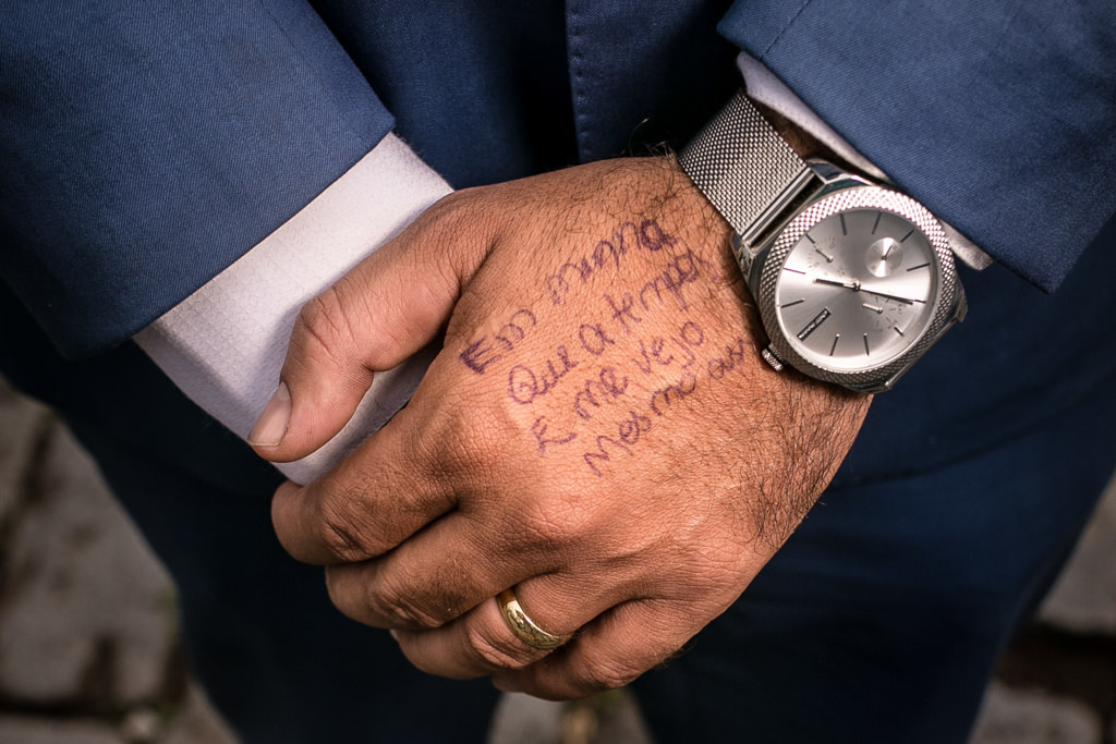 detalhes da mão do noivo pedro com a escrita da música que ele irá cantar para sabrina