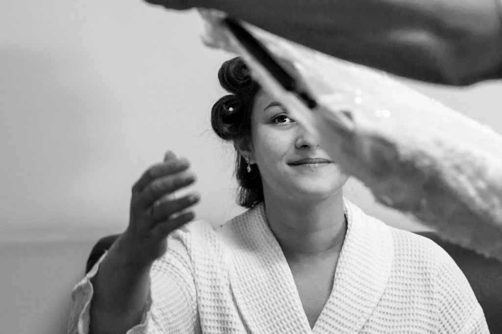 Luciana a noiva sentada recebendo o seu vestido de noiva