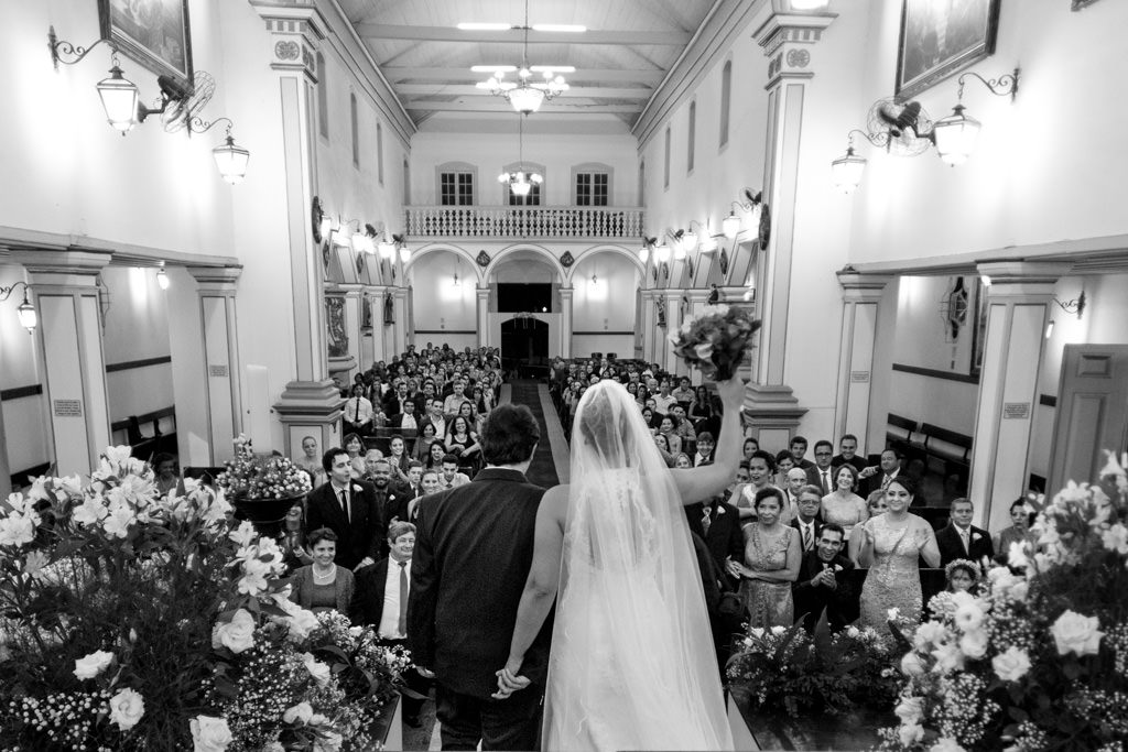 Vista geral interna da Igreja Matriz de Santo Antônio com todos os convidados e os noivos comemorando o Sim