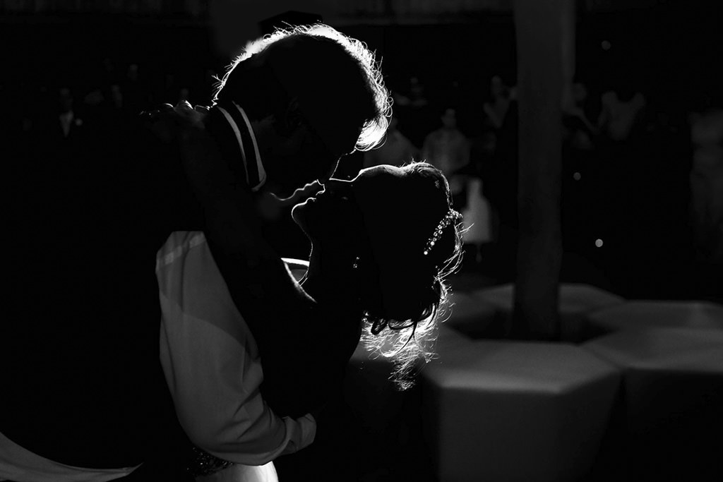 Na festa uma valsa especial para o casal Luciana e Cesar, onde o noivo deita a noiva para beija-la, foto preta e branca somente siluetas