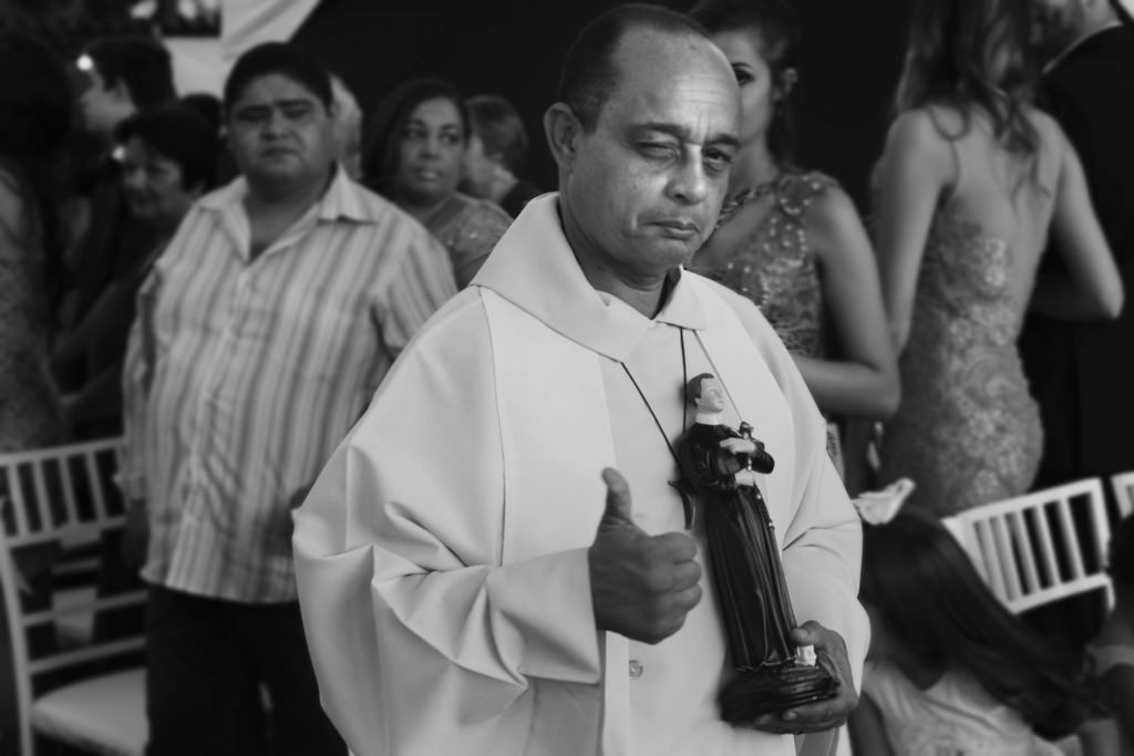 a entrada o padre segurando o Santo Antonio, dando um joia para todos