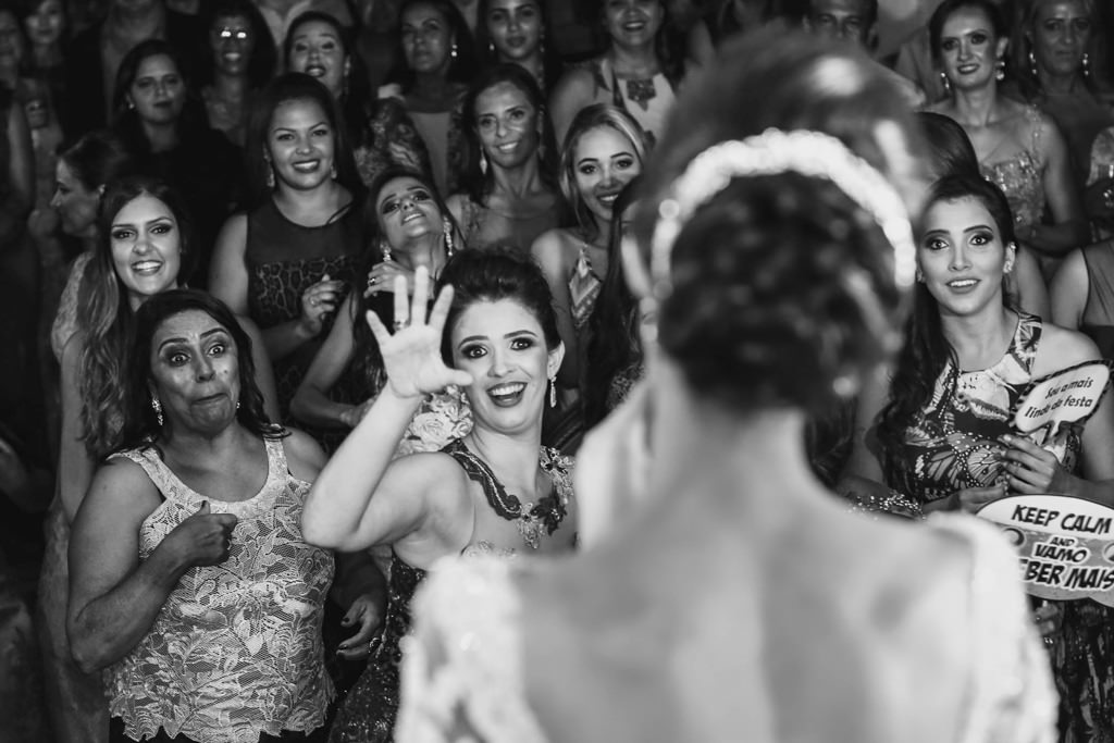 A hora do buque, a noiva mostrando o buque e a sua irmã pedindo