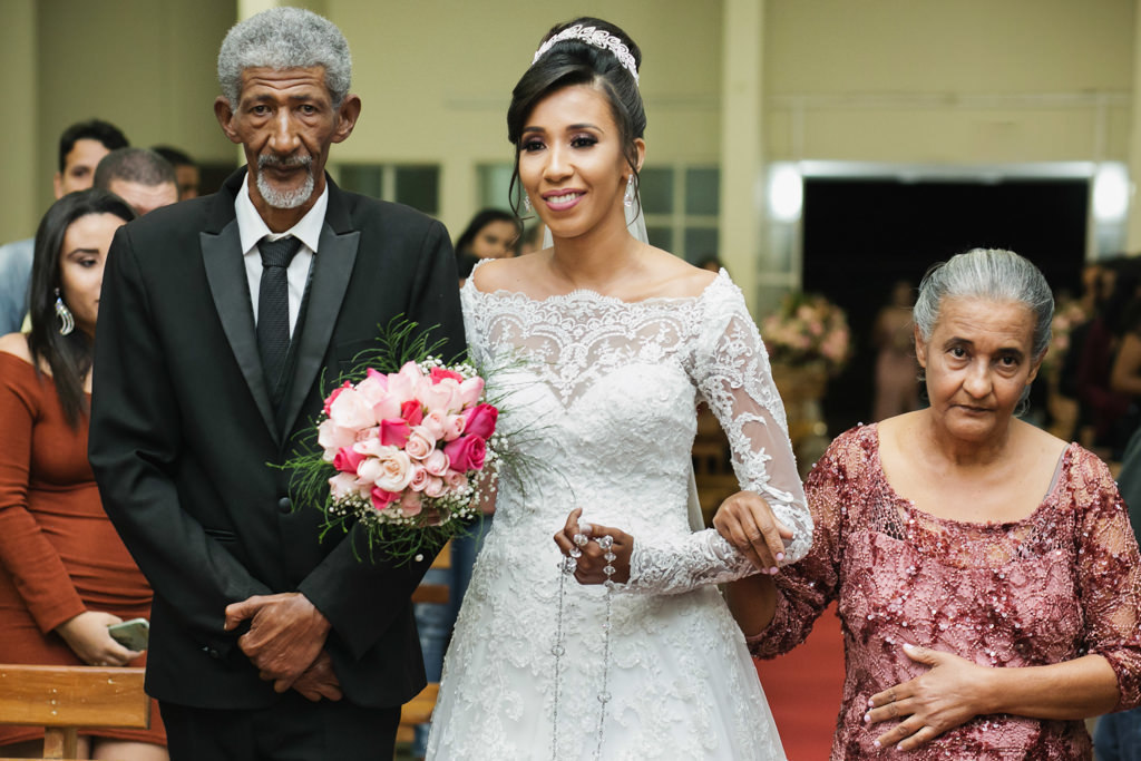 Acompanhada de seus pais a linda Daniela com seu belo vestido de noiva rumo ao altar