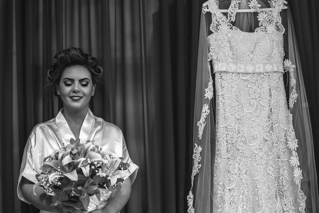 Durante o making of da noiva Andreia, ela segurando o buque ao lado do seu lindo vestido de noiva