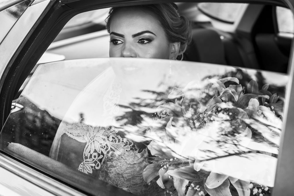 A chegada da noiva de carro, com seu lindo buque e um olhar marcante, minutos antes da grande entrada