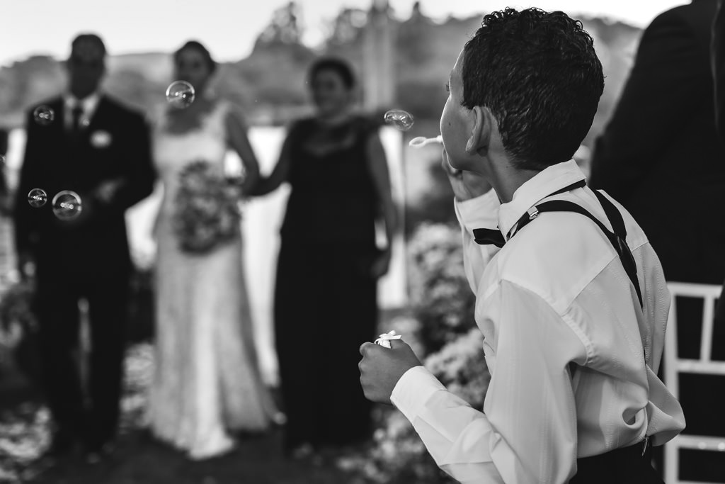 A entrada da noiva Andreia, com foco no pagem com bolinha de sabão