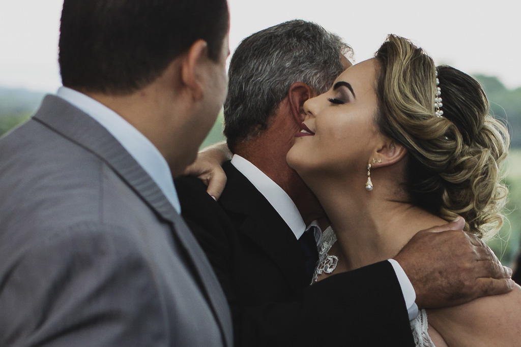 Momento do abraço da linda noiva Andreia em seu pai e Cristiano olhado e esperando para levar até o altar