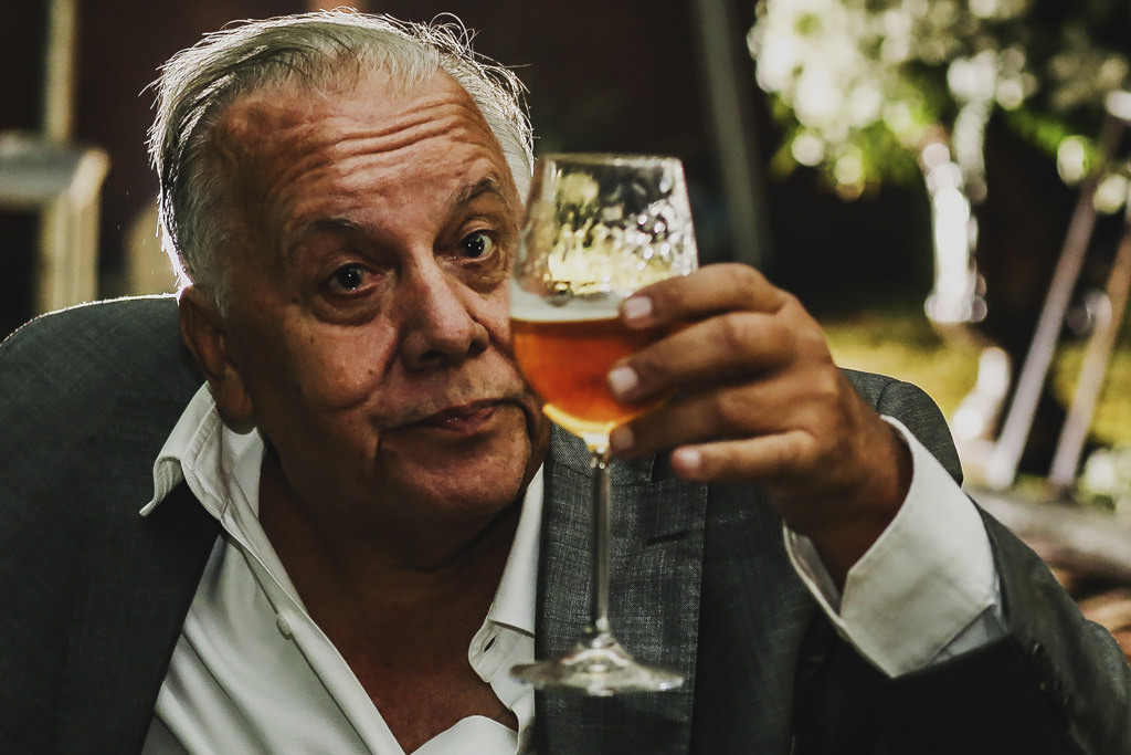 o pai do noivo aproveitando a festa, com a taça de cerveja