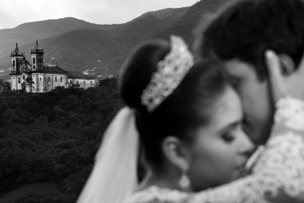 O abraços desfoczado de Adelson e Nayara  com todo carinho e a Igreja Histórica e montanhas de Ouro preto