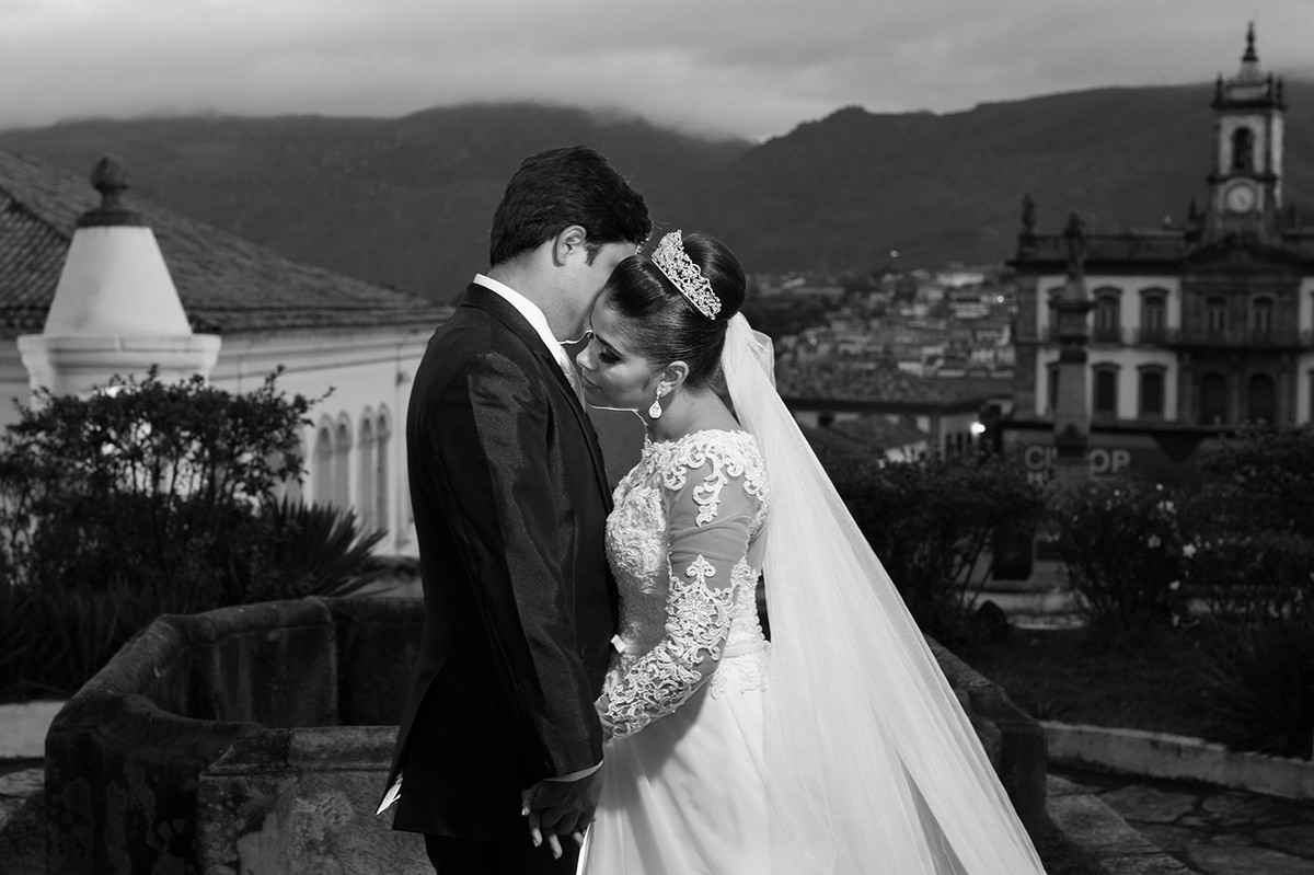 Nayara e Adelson de mãos dadas, com seu lindo vestido de noiva e ao fundo a linda ouro preto