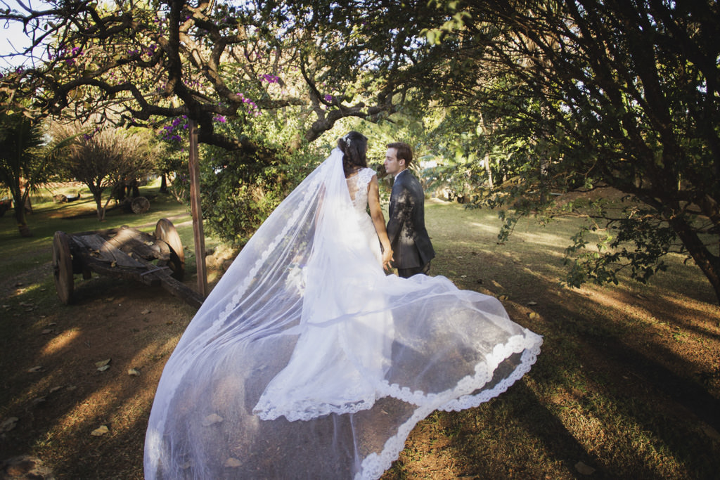 Com o seu enorme véu ao vento completa o seu lindo vestido de noiva de Daniela de mãos dadas a Rafael