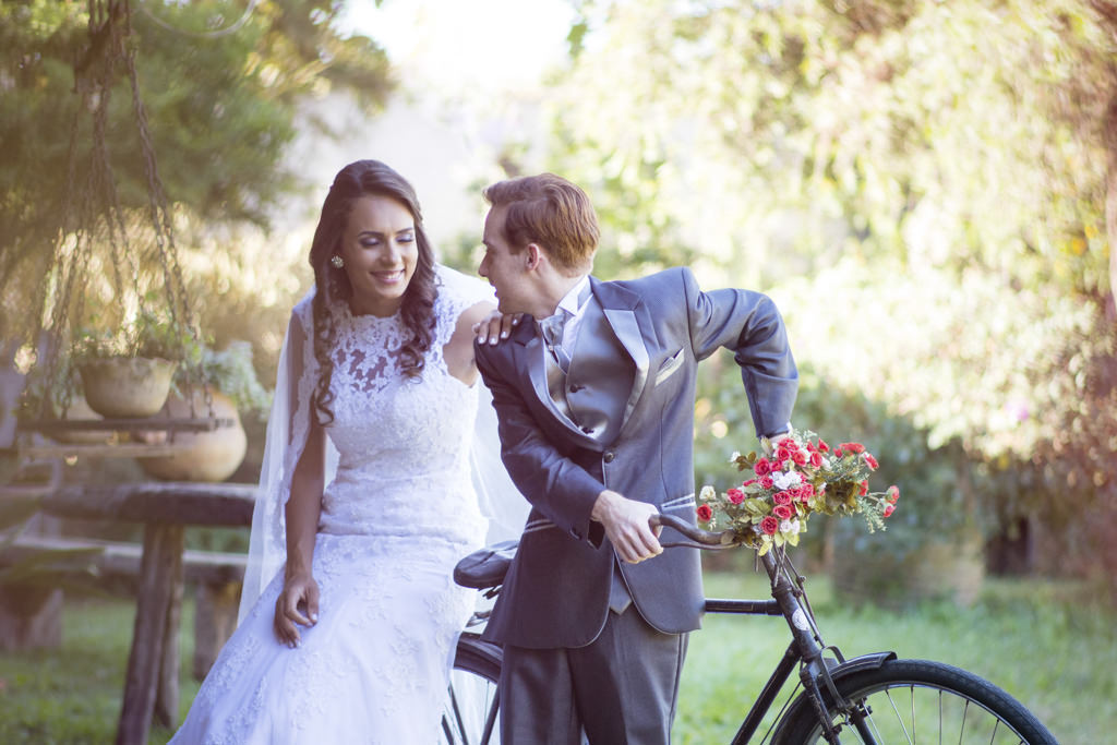 Daniela com seu lindo vestido de noiva sentada em bicicleta antiga e Rafael a levando