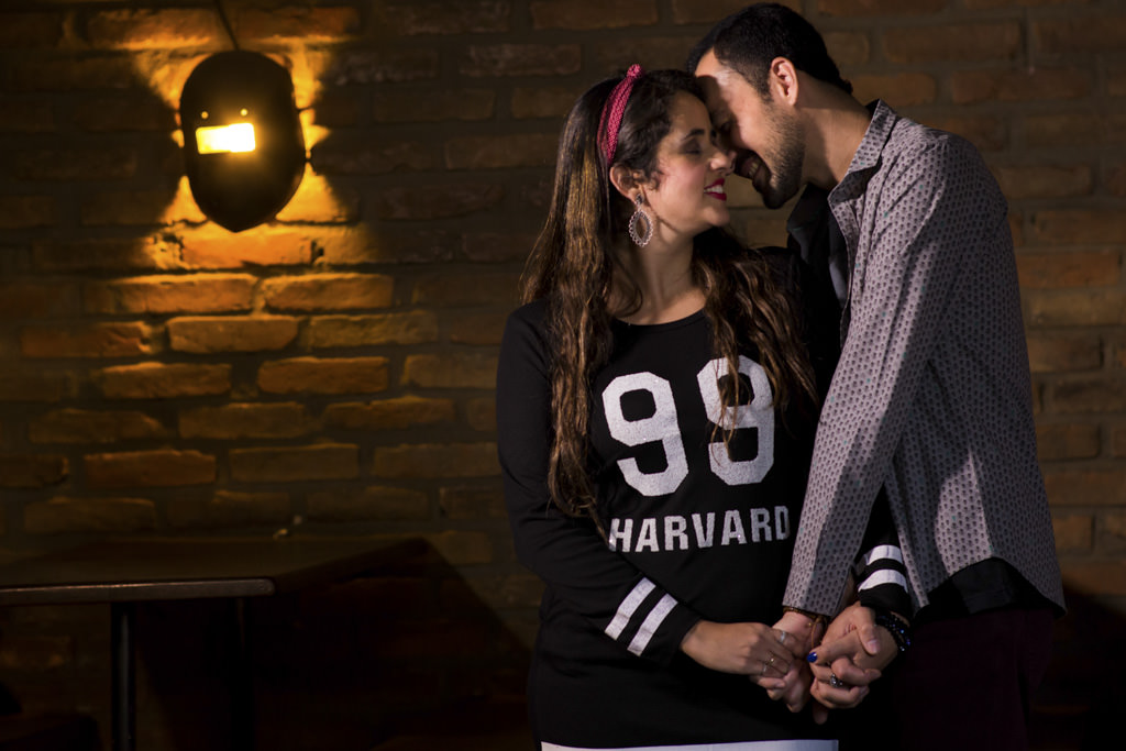 O carinho de Christian em Thammy ao fundo a luminária em formato de uma máscara de solda