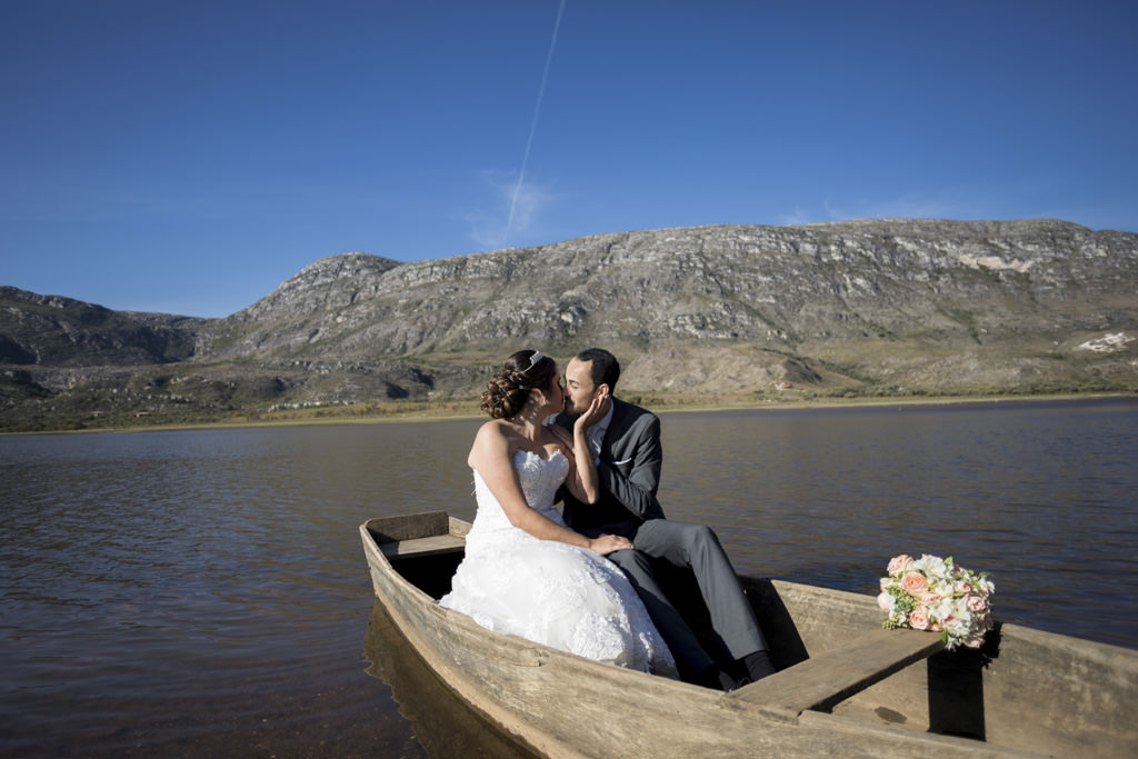 sentado em um barco no meio na lagoa da lapinha da serra com lindo céu azul o beijo dos noivos