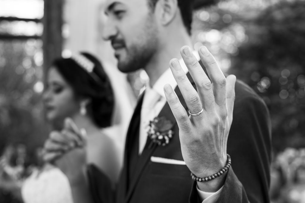 com o foco não mão e na aliança de christian, eles recebem a benção do celebrante