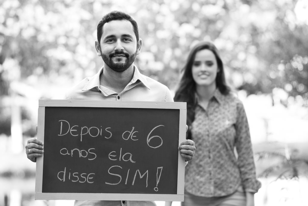 tiago a frente segurando uma placa 