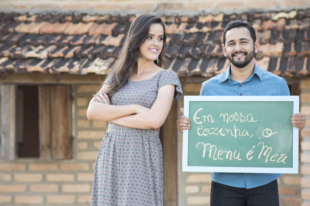 sob o olhar de izabella, tiago segurando a placa informando que o 'menu