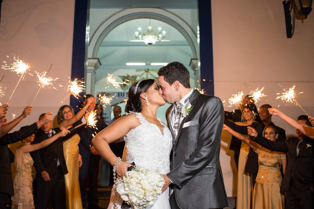 a grande saída com os padrinho fazendo um corredor com fogos e o beijo dos recém casados Cassia e moisés