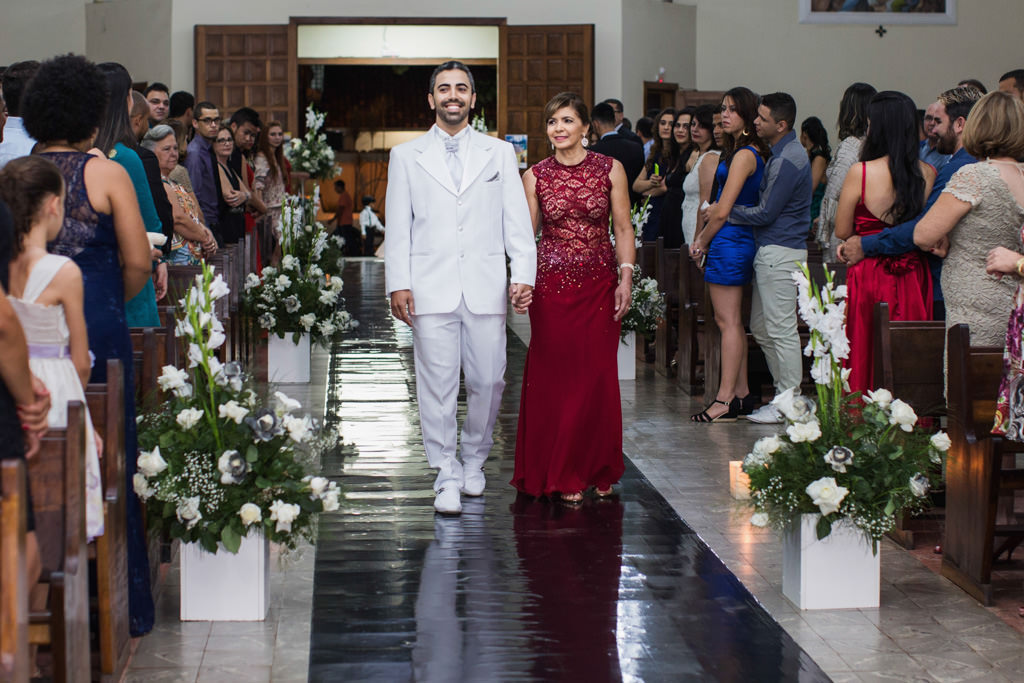 Henrique todo estiloso de terno branco entrando ao lado de sua mãe na Igreja Santa Luzia em sete lagoas