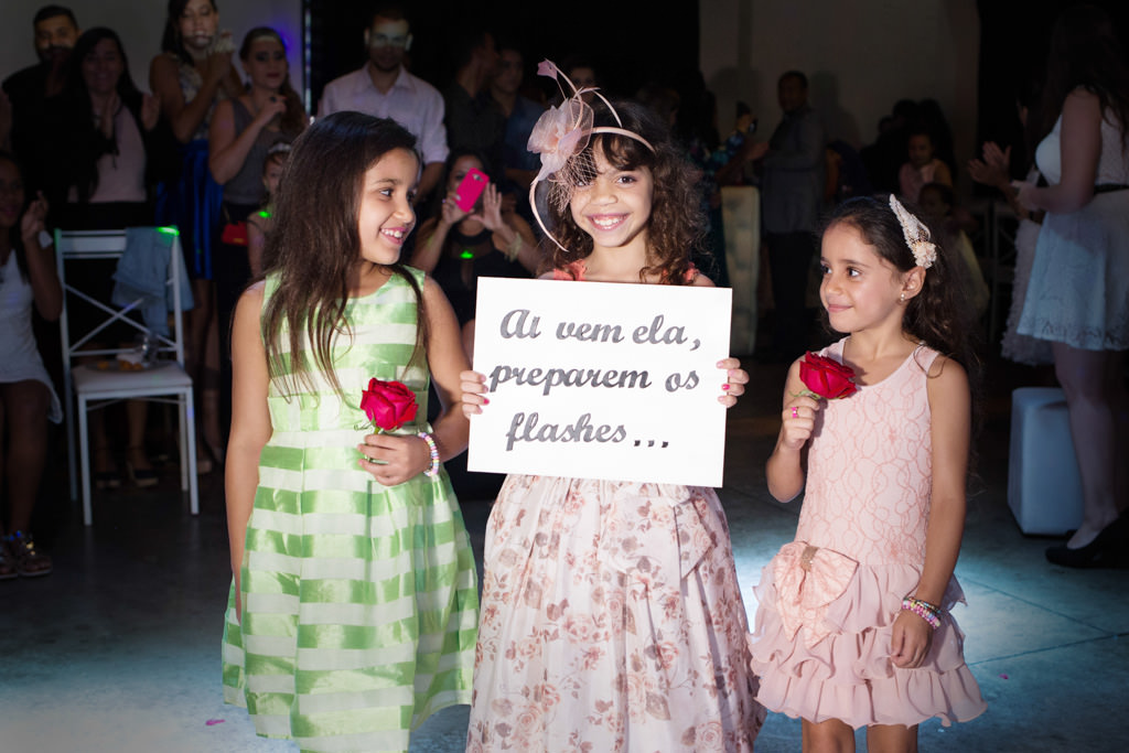 a sua linda irmã segurando  a placa para preparar os flashes para a entrada triunfal da bianca