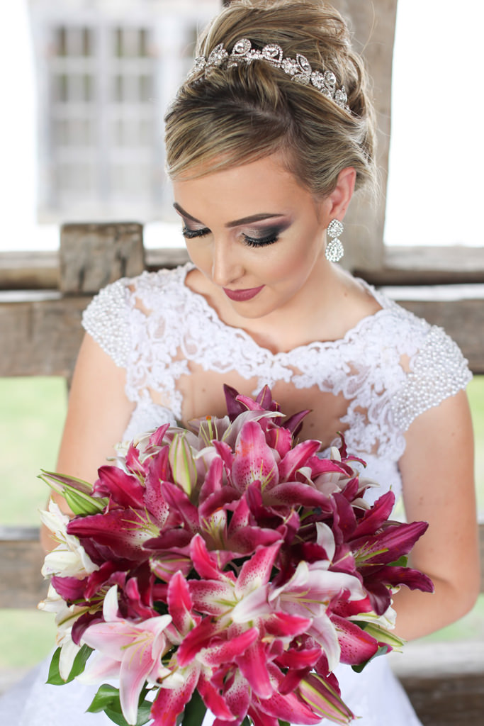 segurando o seu lindo buquê de noiva, mostrando seu lindo vestido, cabelo e maquiagem