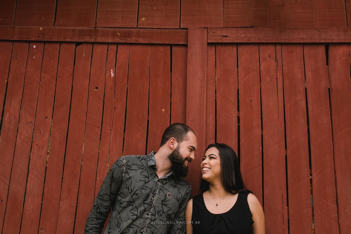 casal sorrindo e se olhando em frente a porta de madeira no municipio de domingos martins, no espirito santo