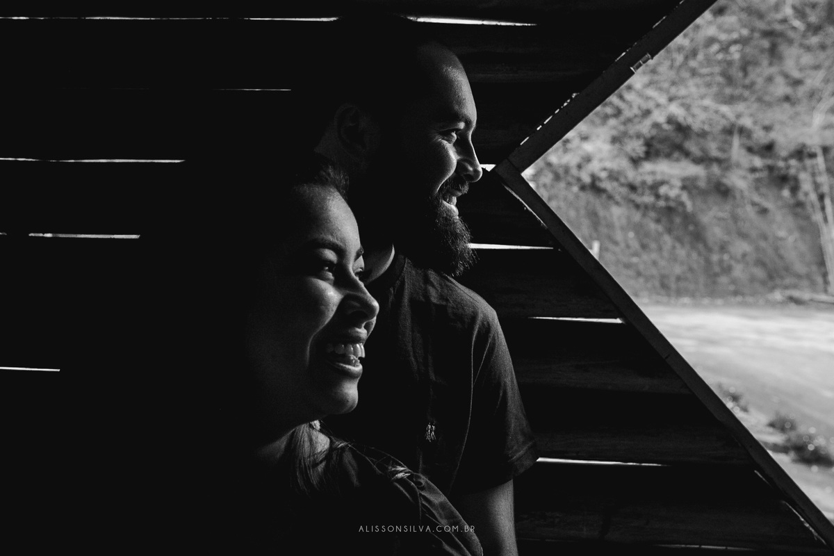 foto em preto e branco de casal olhando pela janela