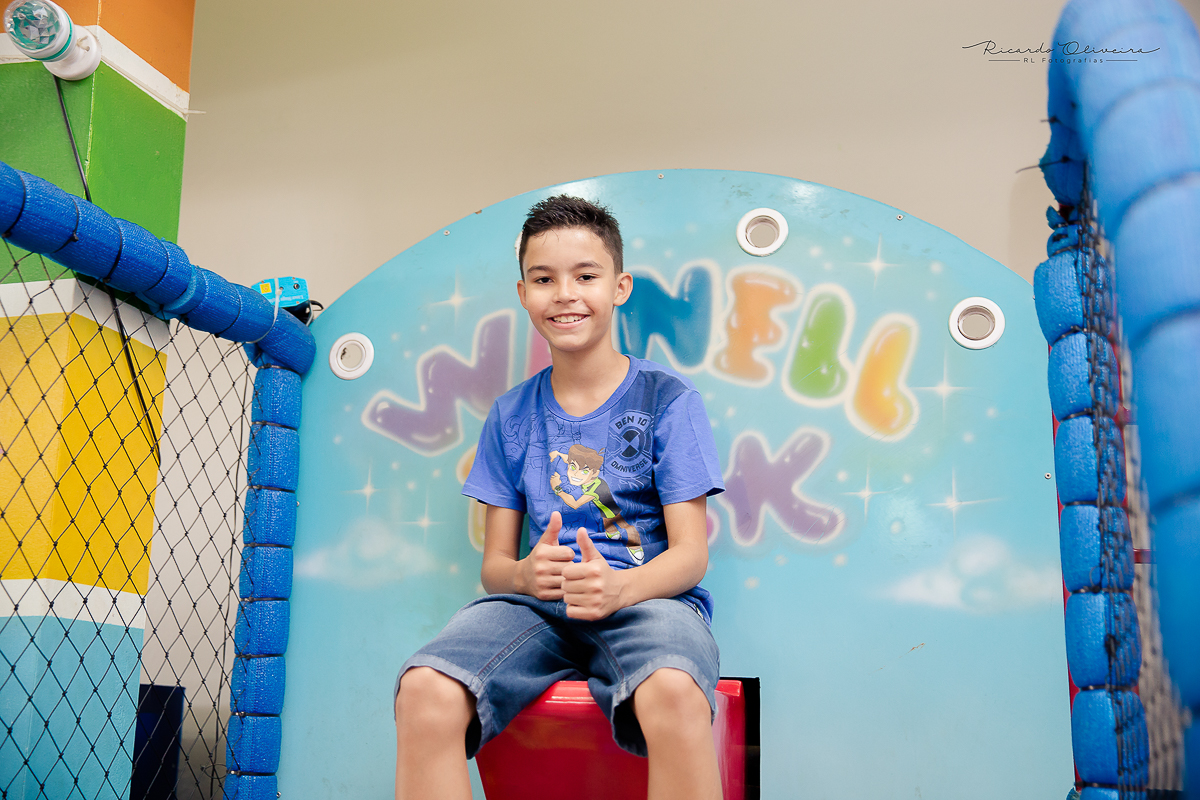 O garotão fazendo pose para a foto de cima do brinquedo