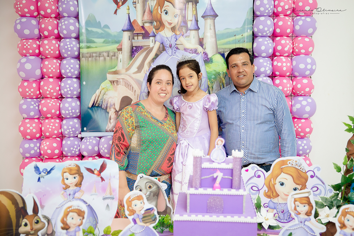 O papai e a mamãe junto da Melissa vestida de princesa posando para as fotos