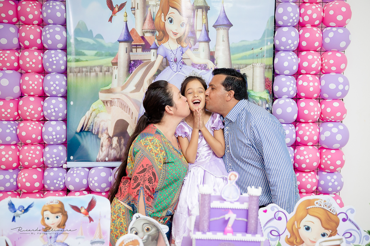 å melissa adorou o papai e a mamãe beijando ela atras da mesa do bolo